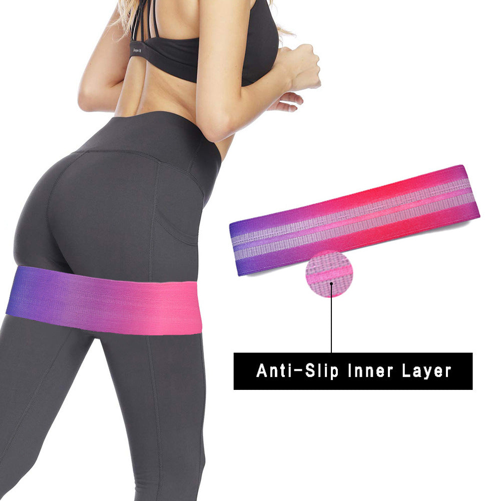 Person wearing black leggings with a pink and purple resistance band, highlighting the anti-slip inner layer.